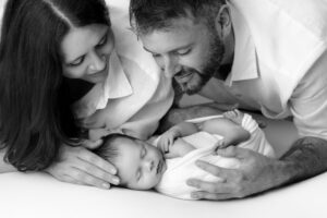 Newborn baby cuddled by its parents photographed by leading newborn photographer Melanie East in Bristol