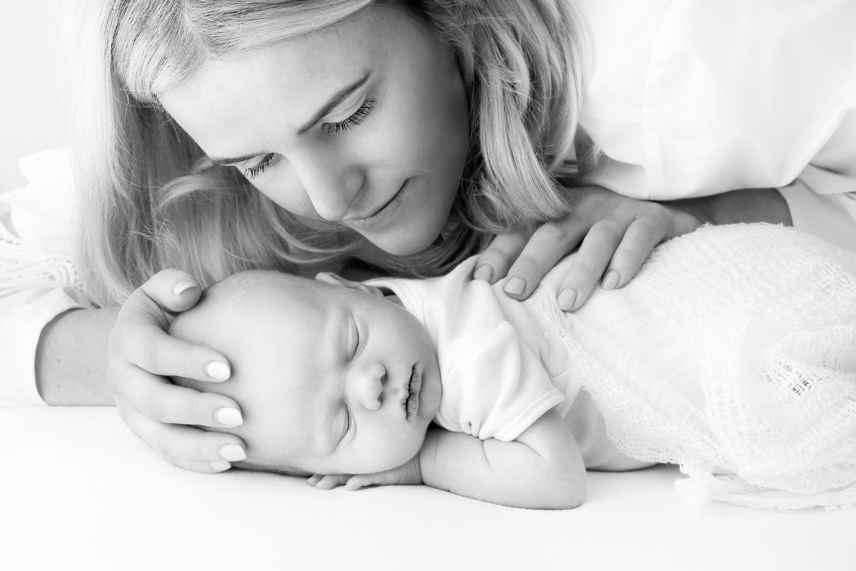 tender photograph of a newborn baby with it's mother in black and white photographed by Melanie East baby photographer in Bristol